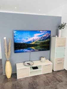 a living room with a flat screen tv on a wall at Gemütliche Neubauwohnung 70qm in Eichenzell