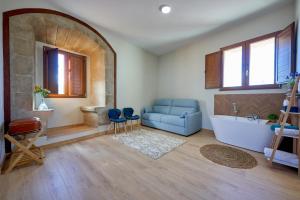a living room with a blue couch and a tub at Dùplex Argollas Grand Suite Centro Parking gratis in Plasencia