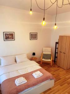 a bedroom with a bed and a chair and lights at Apartament Plopilor Studios in Sibiu +28 photos