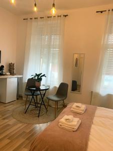 a bedroom with a bed and a table and chairs at Apartament Plopilor Studios in Sibiu