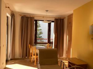 a living room with a table and a chair at Apart Hotel Flora Residence - Clover Building Flat 09 in Borovets