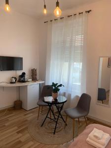 uma sala de estar com uma mesa, 2 cadeiras e uma secretária em Apartament Plopilor Studios em Sibiu