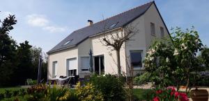 une maison blanche avec un toit noir dans l'établissement Chambre d'hôtes du Haut Chemin, à La Bohalle