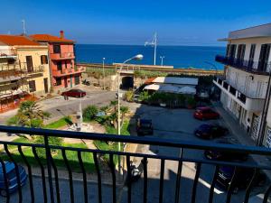 a balcony with a view of a street and the ocean at Appartamento Vacanza Gioiosamare in Gioiosa Marea