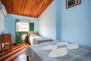 a bedroom with two beds and a table and a window at Pousada Nossa Casa in Lençóis