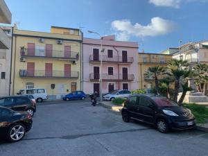 a parking lot with cars parked in front of buildings at Appartamento Vacanza Gioiosamare in Gioiosa Marea