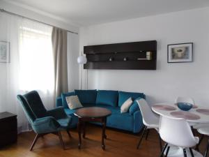 a living room with a blue couch and a table at Apartament 19 Delux- Bliżej Zdroju in Polanica-Zdrój