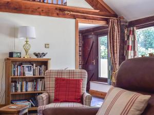 a living room with a chair and a book shelf at Angel Cottage in Oswaldkirk
