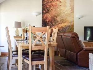 a dining room with a table and a couch at Angel Cottage in Oswaldkirk