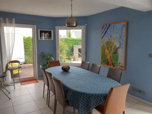ein blaues Esszimmer mit einem Tisch und Stühlen in der Unterkunft Chambre d'hôtes du Haut Chemin in La Bohalle