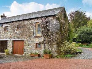 ein altes Steinhaus mit einer Holzgarage in der Unterkunft Lake View Farm in Watermillock