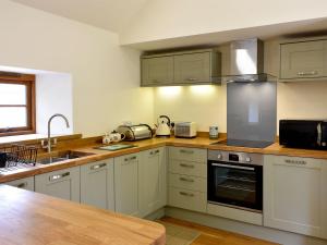 a kitchen with white appliances and a wooden counter top at Lake View Farm in Watermillock