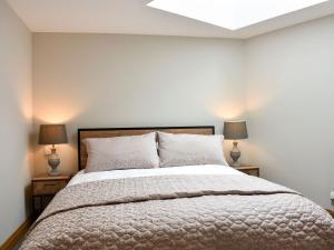 ein Schlafzimmer mit einem großen Bett mit zwei Lampen in der Unterkunft Lake View Farm in Watermillock