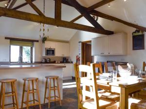 a kitchen and dining room with a wooden table and chairs at Swallow Barn in Banbury