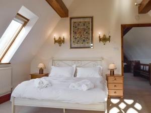 a bedroom with a white bed with towels on it at Swallow Barn in Banbury