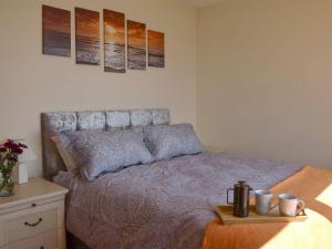 a bedroom with a bed with three paintings on the wall at Seashore Retreat in Johnshaven