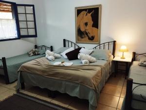 1 dormitorio con 2 camas y una foto de caballo en la pared en Estância das Angolas - Inhotim, en Brumadinho