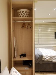 a room with a bedroom with a bed and a closet at London Luxury 1 bed flat 4 mins to Ilford Stn - kitchen, garden, parking, WiFi in Ilford