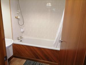 ein Badezimmer mit einer Badewanne und einem Waschbecken in der Unterkunft Impeccable 2-Bed Flat in Wick in Wick