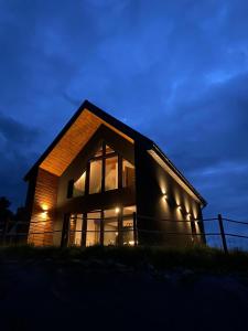 a house with lights on the side of it at night at Stodoła Nad Skawą in Sucha Beskidzka