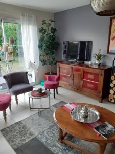 sala de estar con TV y mesa en Chambre d'hôtes du Haut Chemin, en La Bohalle