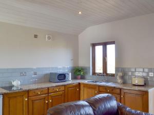 a kitchen with a microwave and a couch in it at Fern Lodge - Uk13321 in Melbourne