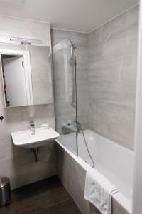 a bathroom with a sink and a tub and a shower at Apartmán s nádherným výhledem v centru Harrachova in Harrachov