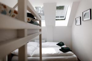 a small white bedroom with a bed and a window at Luxusní horský apartmán v centru Harrachova in Harrachov