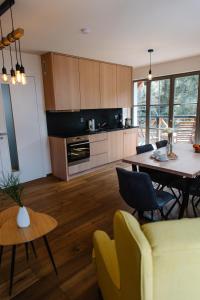 a kitchen and living room with a table and chairs at Luxusní horský apartmán v centru Harrachova in Harrachov
