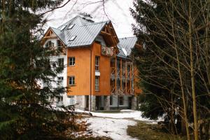 a large building in the middle of a forest at Luxusní horský apartmán v centru Harrachova in Harrachov