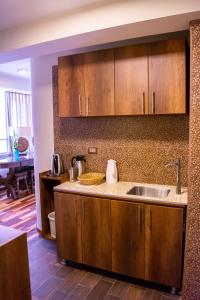 a kitchen with wooden cabinets and a sink at Zans Apartments Cusco in Cusco