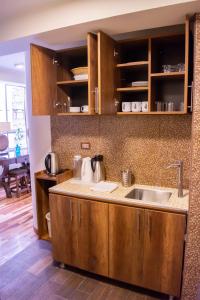 una cocina con armarios de madera y fregadero en Zans Apartments Cusco en Cuzco