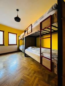 Hostel Prishtina Backpackers في بريشتيني: سريرين بطابقين في غرفة بجدران صفراء