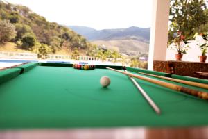 a pool table with two cue sticks and a ball at Dourada Parque Hotel in Pedra Dourada