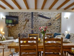 a dining room with a wooden table and chairs at The Hen House in Llanfair-ar-y-bryn