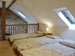 drie bedden in een kamer met een zolder bij The Hen House in Llanfair-ar-y-bryn