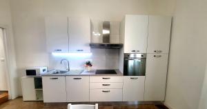 kuchnia z białymi szafkami i zlewem w obiekcie Suite Speciosa Bestvacationever w Cagliari