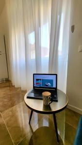 laptopa na stole z kubkiem do kawy w obiekcie Suite Speciosa Bestvacationever w Cagliari +23 zdjęcia