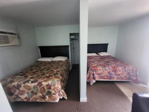 two beds in a small room with two beds sidx sidx sidx at Night Inn Grand Forks in Grand Forks