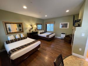 a large room with two beds and a couch at Sea Breeze Inn - Pacific Grove in Pacific Grove