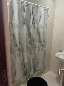 a marble shower curtain in a bathroom with a sink at Apartamento Vila Santa Bárbara ,Bloco F RChão Dirt,Santo Antão,Cabo Verde in Mão para Trás