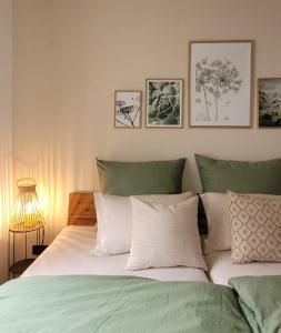 a bedroom with a bed with green and white pillows at Ferienwohnung Anna Maria Erding in Erding