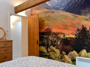 a bedroom with a mountain mural on the wall at Taylors Cottage in Threlkeld