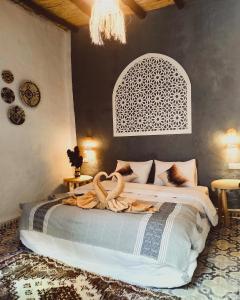 1 dormitorio con 1 cama grande y cabecero blanco en Casa Hamid, en Merzouga
