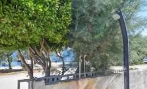 a street light next to a wall with trees at Apartments Anita in Ugrinići