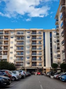 a large building with cars parked in a parking lot at Clarissa apartment City Kvart in Podgorica