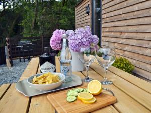 a table with a bottle of wine and a plate of chips and a bowl at Caban Caru in Dinas Mawddwy