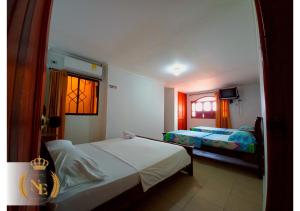- une chambre avec 2 lits et une fenêtre dans l'établissement Hotel Nueva Esperanza, à Barranquilla