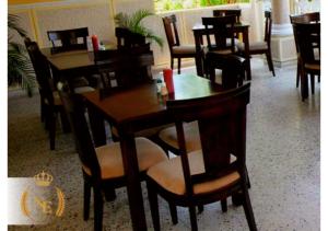 Hotel Nueva Esperanza في بارانكويلا: غرفة طعام مع طاولات وكراسي خشبية