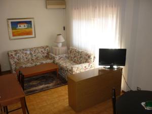 uma sala de estar com um sofá e uma televisão em Eur Nir Residence em Roma